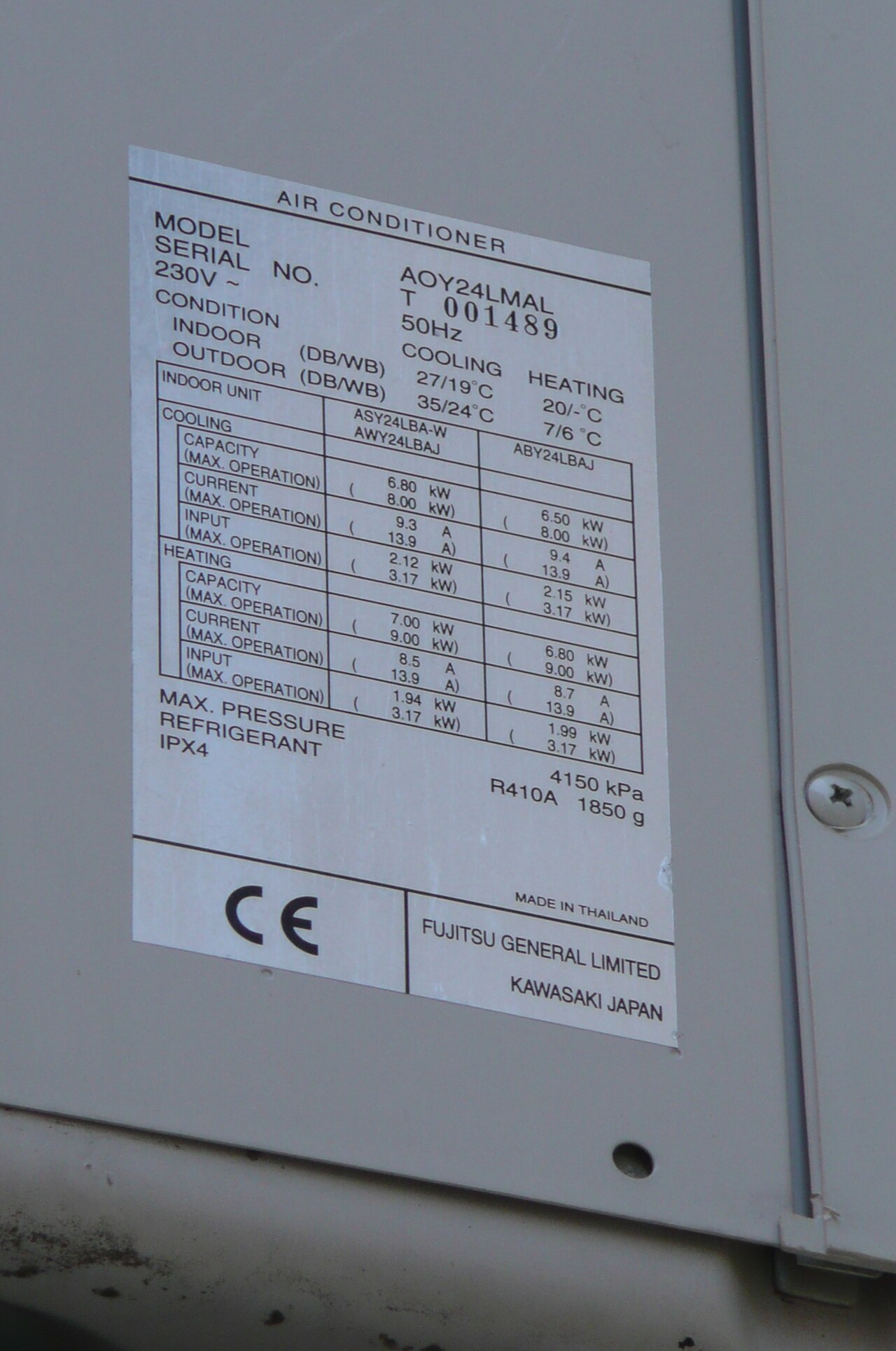 Placa de características de una unidad exterior fotografiada de cerca con el móvil: se leen el refrigerante R-410A y la carga, 1.850 g.
